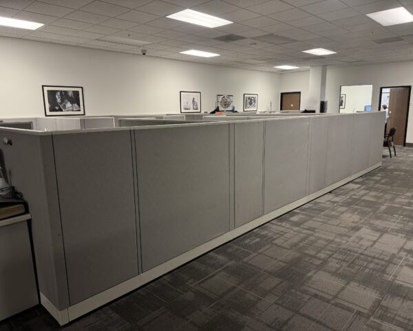 Grey office cubicle workstations with overhead storage