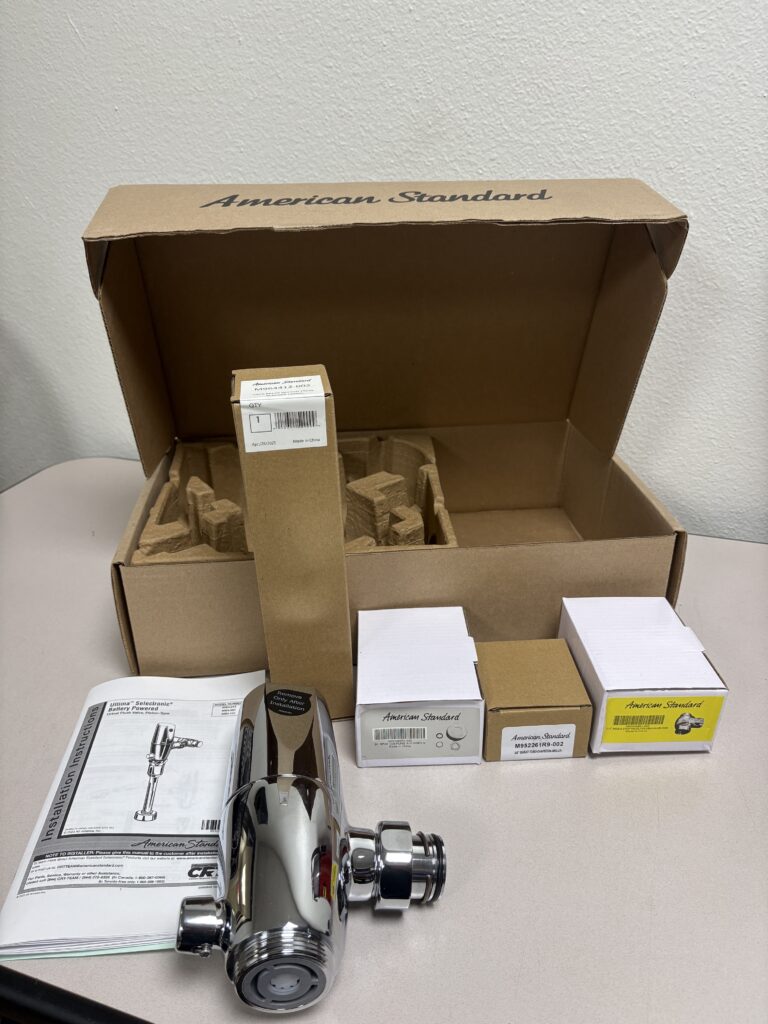 Open box showing the 6064013.002 urinal flush valve and fittings