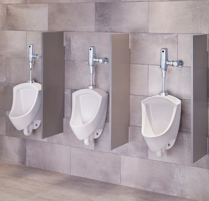 Row of commercial urinals fitted with American Standard flush valves