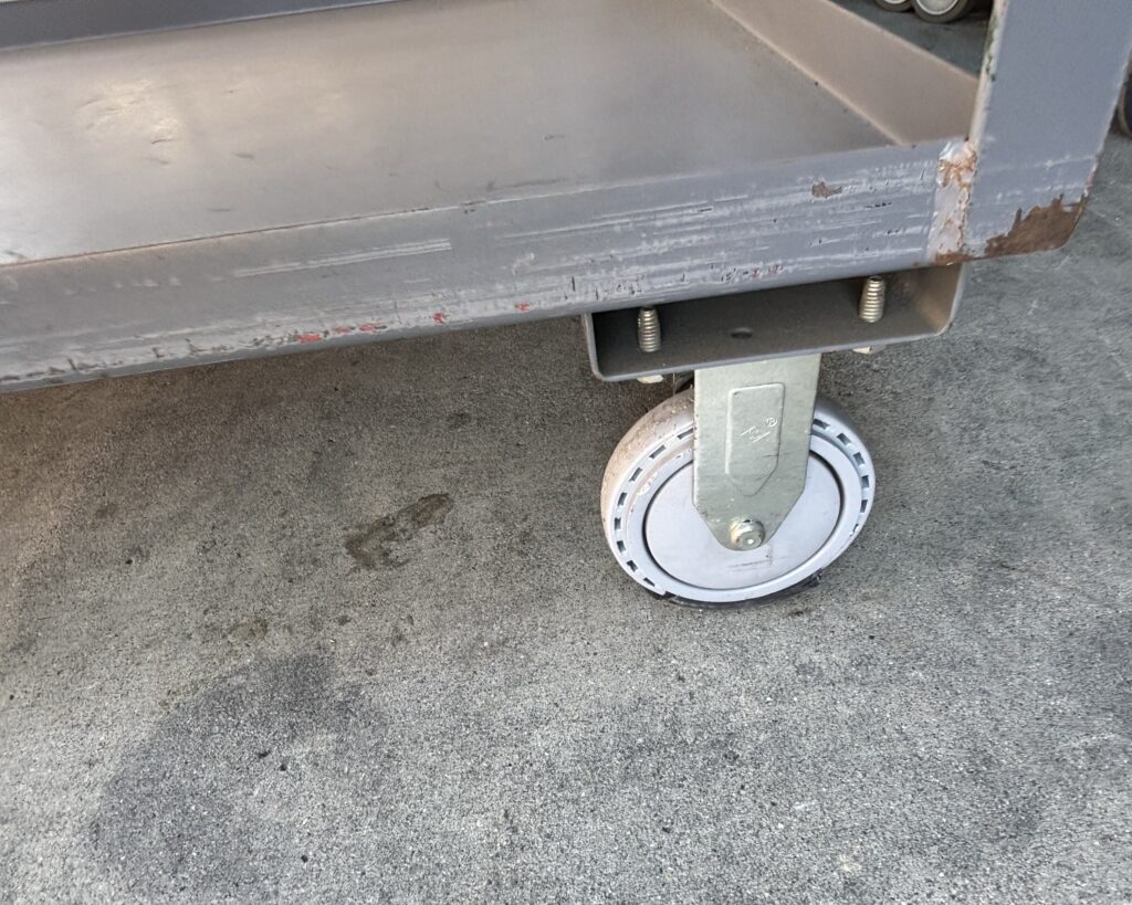 Close-up of a heavy-duty swivel caster on an industrial cart
